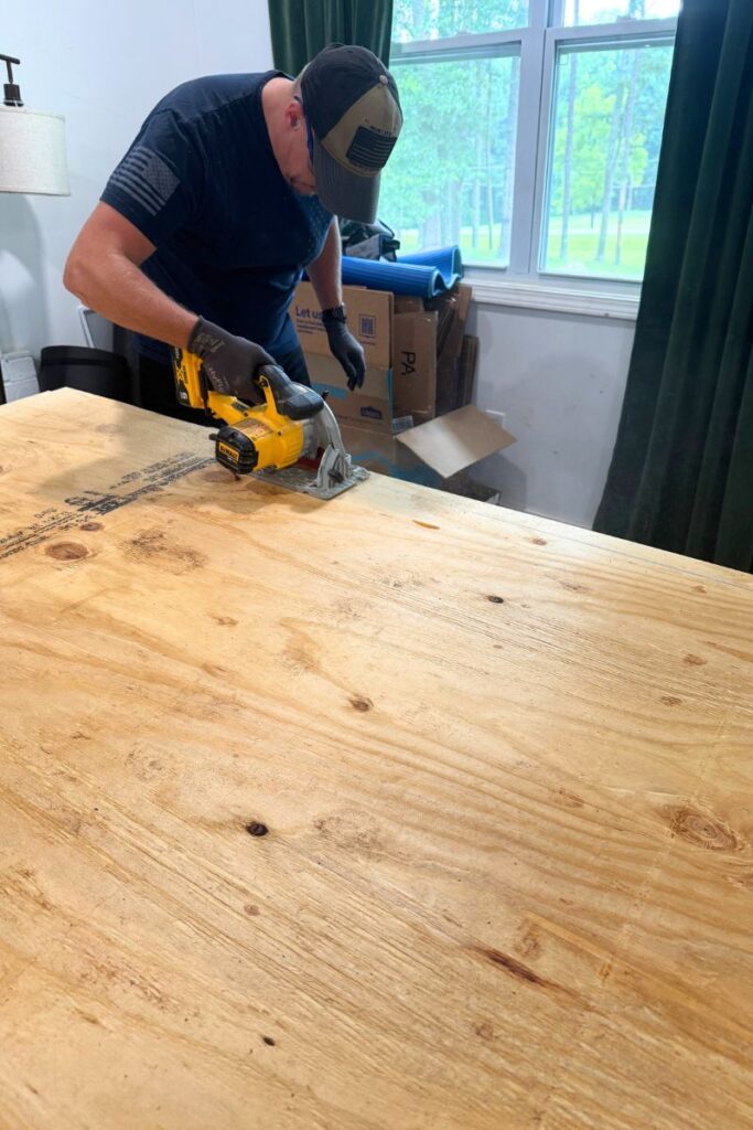 Using a skils saw to cut the edges off the plywood